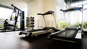 A gym with cardio equipment, weight machines, and dumbbells. - GP Plaza Apartment (Jakarta)