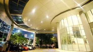 A modern building with a curved glass facade and a large, illuminated ceiling. - GP Plaza Apartment (Jakarta)