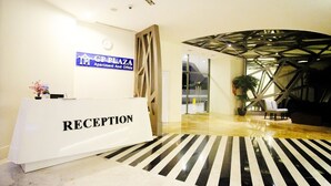 A reception area with a 'RECEPTION' sign, a clock, and a 'GP PLAZA Apartment And Office' sign. - GP Plaza Apartment (Jakarta)