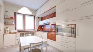 Frigorífico grande, placa de cocina y utensilios de cocina