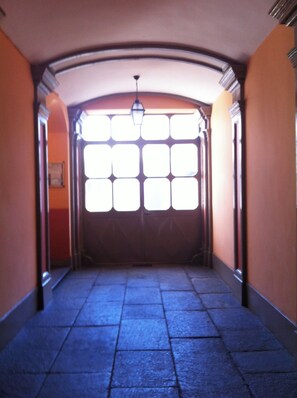 Ein Flur mit Fliesenboden und einem großen Fenster am Ende.