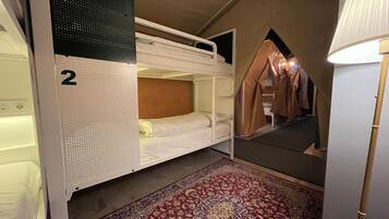 A bunk bed room with a number 2 bunk, a patterned rug, and a tent-like structure.