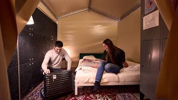 Een kamer met een bed, een koffer, een garderobe en een kaart op het bed.