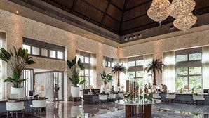 A spacious lobby with a high ceiling, large windows, and multiple seating areas. - Stunning Grand Luxxe 2-Bedroom Loft, Perfect for you to indulge in paradise. (Nuevo Vallarta)