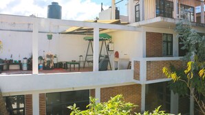 A multi-story building with a balcony, a water tank, and potted plants. - Live like a local in San Cris! Pets welcome! (San Cristóbal de las Casas)