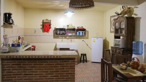 A kitchen with a brick island, a refrigerator, a microwave, and a water dispenser. - Live like a local in San Cris! Pets welcome! (San Cristóbal de las Casas)
