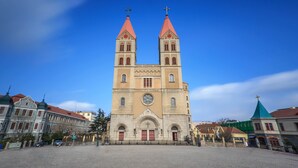 Une grande église dotée de deux tours et d’une horloge centrale.