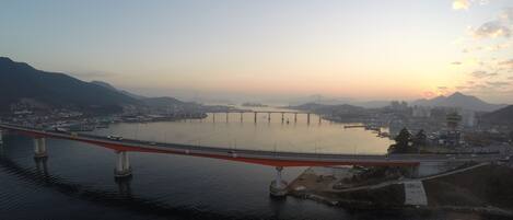 Un puente cruza un río ancho con un paisaje urbano al fondo.