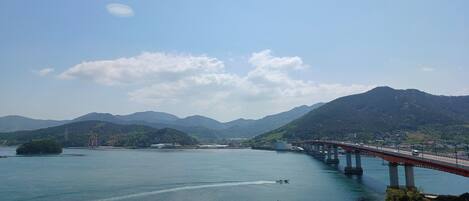 A bridge over a river with mountains in the background.