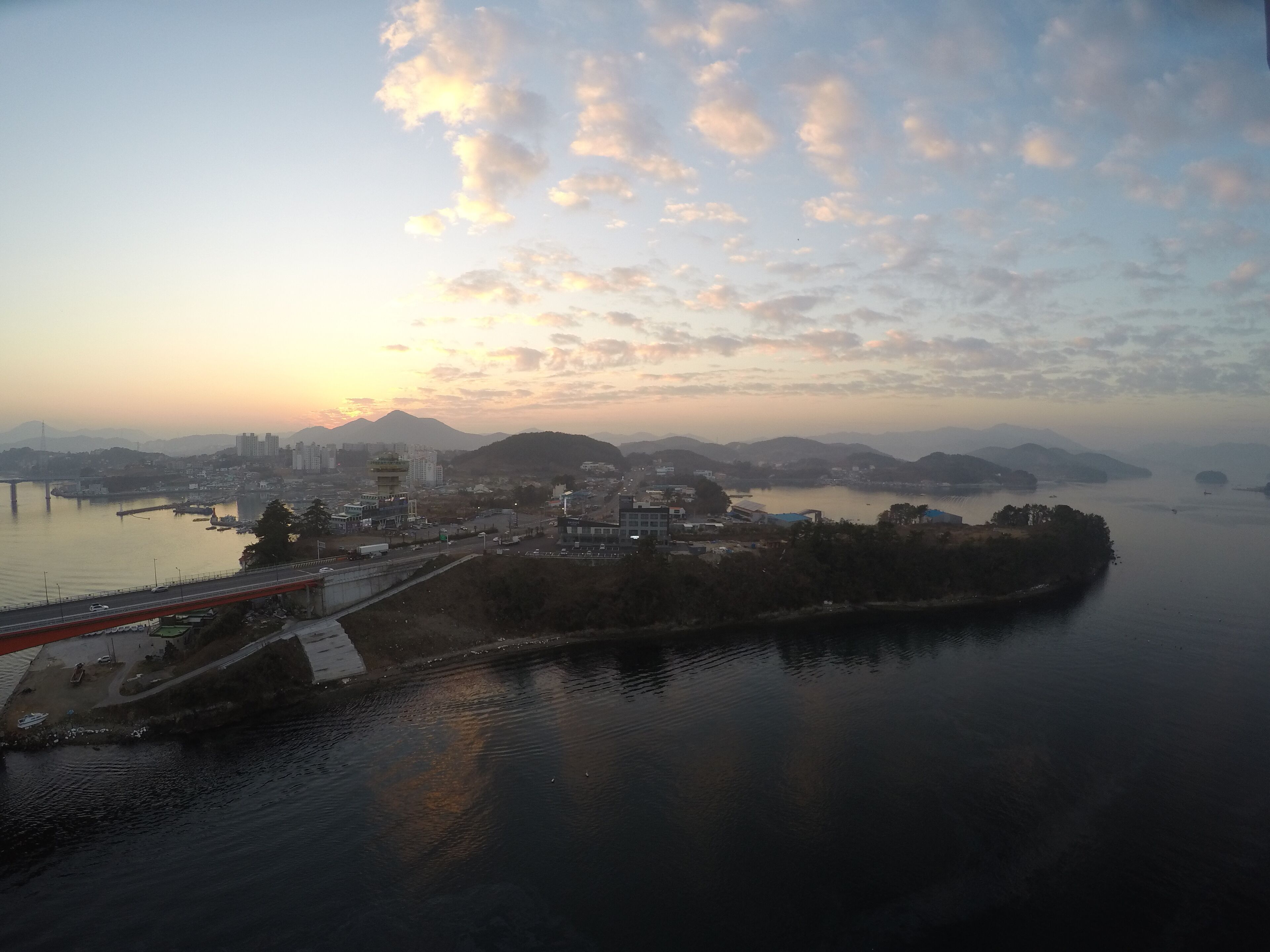 Una vista panoramica di una città costiera con un ponte, una torre e un fiume tranquillo.