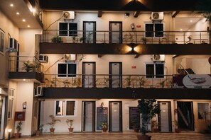 A multi-story building with balconies, air conditioning units, and potted plants. - Hotel Maple Delite (Lucknow)