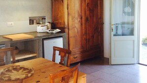 Eine Küche mit einem Holzkorpus, einem Esstisch mit Stühlen und einem Kühlschrank.
