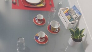A dining table set with plates, cutlery, and a potted plant.