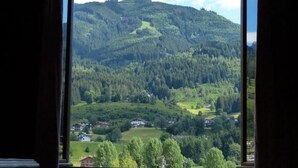 Une pièce dotée d’une grande fenêtre donnant sur une vallée verdoyante et des collines.
