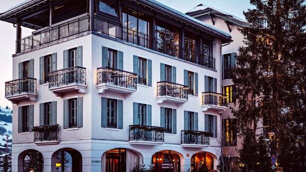 A multi-story hotel with balconies, arched windows, and a restaurant sign.