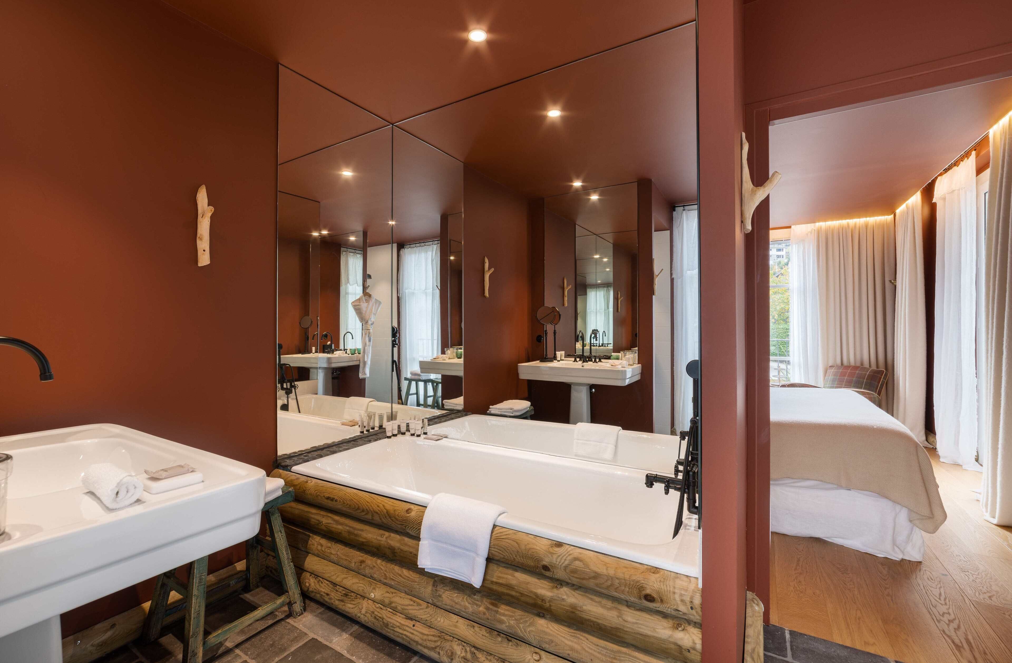 A modern bathroom with a wooden vanity, a large bathtub, and a separate shower area.