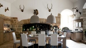 Uma cozinha rústica com paredes de pedra, lareira e decorações de chifres de veado.