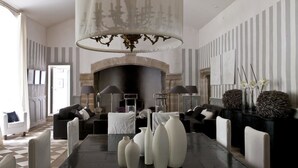 Uma sala de estar espaçosa com lareira, móveis modernos e um candelabro.