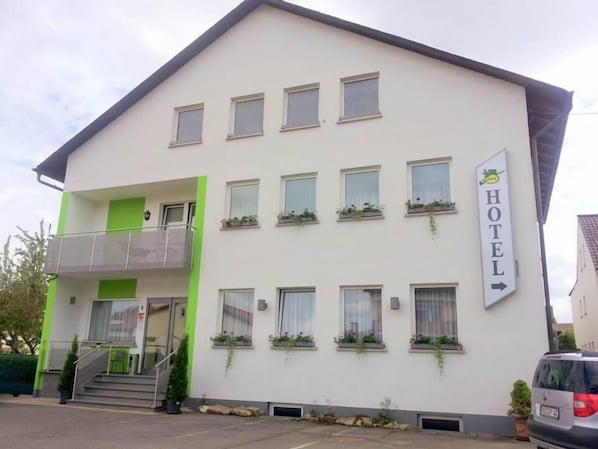 A two-story hotel with a balcony on the ground floor, multiple windows with flower boxes, and a sign indicating the hotel's name. - Hotel Garni Försterhof (Kronach)