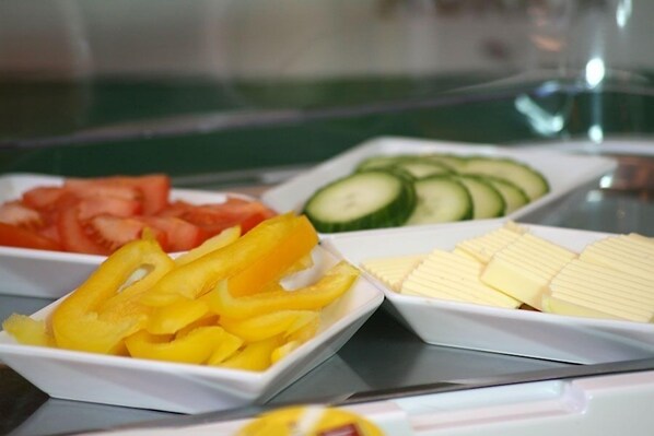 A buffet with sliced fruits and vegetables. - Hotel Garni Försterhof (Kronach)