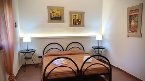 Ein ordentlich eingerichtetes Schlafzimmer mit einem Bett, zwei Nachttischen und zwei Wandleuchten.