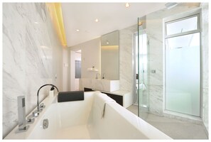 A modern bathroom with a freestanding bathtub, a glass shower enclosure, and a large mirror.