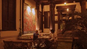Un comedor tradicional con muebles de madera y un amplio biombo decorativo.
