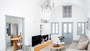 Una sala de estar moderna con televisor, sofá y comedor.