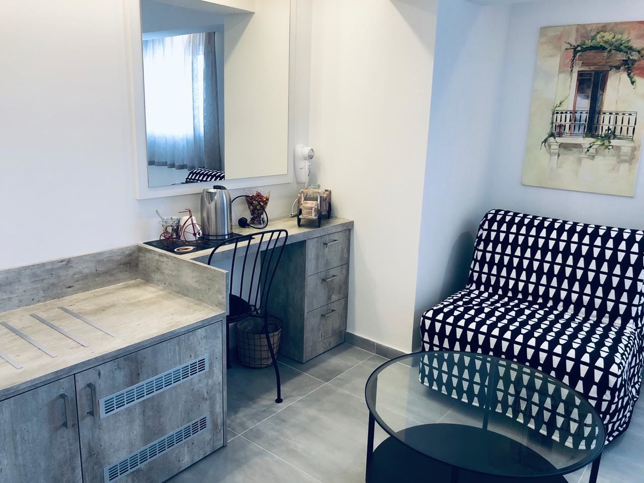 Une salle de bain moderne avec un meuble-lavabo, une chaise et une petite table.
