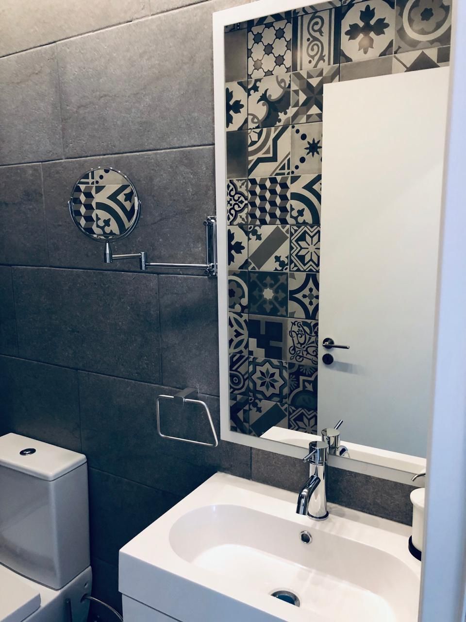 A modern bathroom with a shower, a sink, and a toilet.
