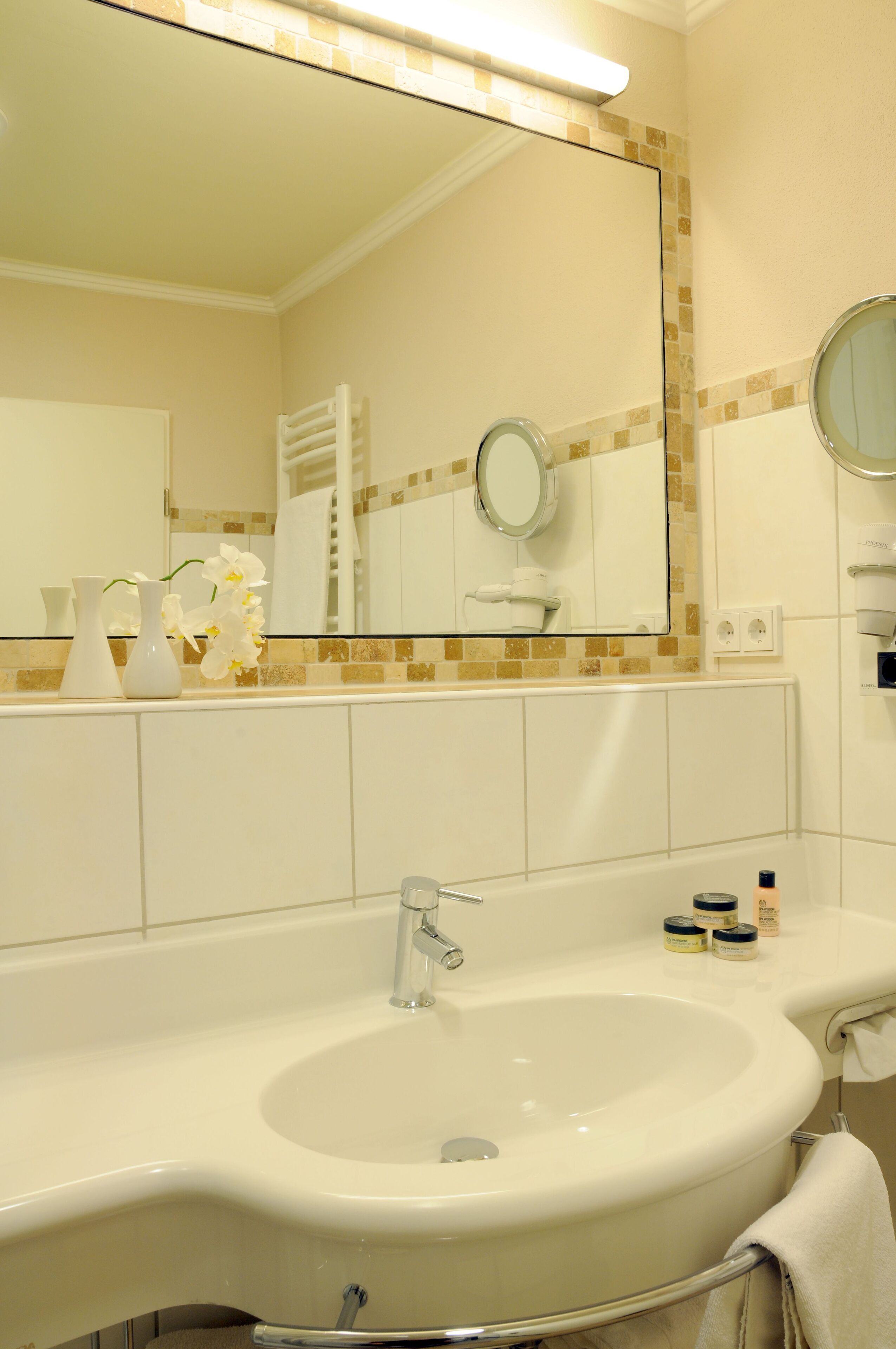 Un baño con un lavamanos grande, un espejo y un perchero para toallas.