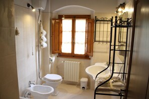 Tina con regadera, secadora de cabello, bidet, toallas 