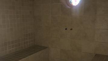 Bathroom features a bench and a circular stained glass window.