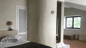 Un dormitorio con cama, lámpara, ventana y vistas al exterior.