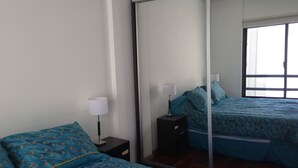 A bedroom with two beds, a mirror, a nightstand, and a window. - Beautiful bright apartment located in the best area of Palermo with 2 bathrooms! (CABA)