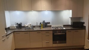 Uma cozinha moderna com forno embutido, cafeteira e fogão a gás.
