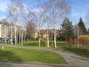 Stroll through the beautifully manicured lawn and paved walkway, surrounded by mature trees and traditional architecture.