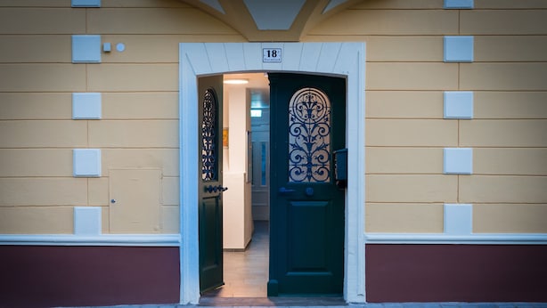 A building entrance with a green door, numbered 18, and a decorative metal gate. - Appartementhaus Hohe Tauern (Obervellach)
