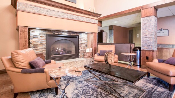 A cozy lounge area with leather sofas, a fireplace, and a coffee table. - Vrbo Property (Wisconsin Dells)