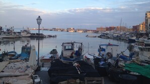 Un puerto deportivo con barcos amarrados, una farola y edificios al fondo.