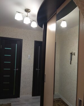 Experience the stylish hotel room with a large mirror, ceiling light fixture, and comfortable carpeted floor.