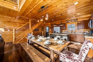 Cozy cabin with a dining area, staircase, and modern kitchen.
