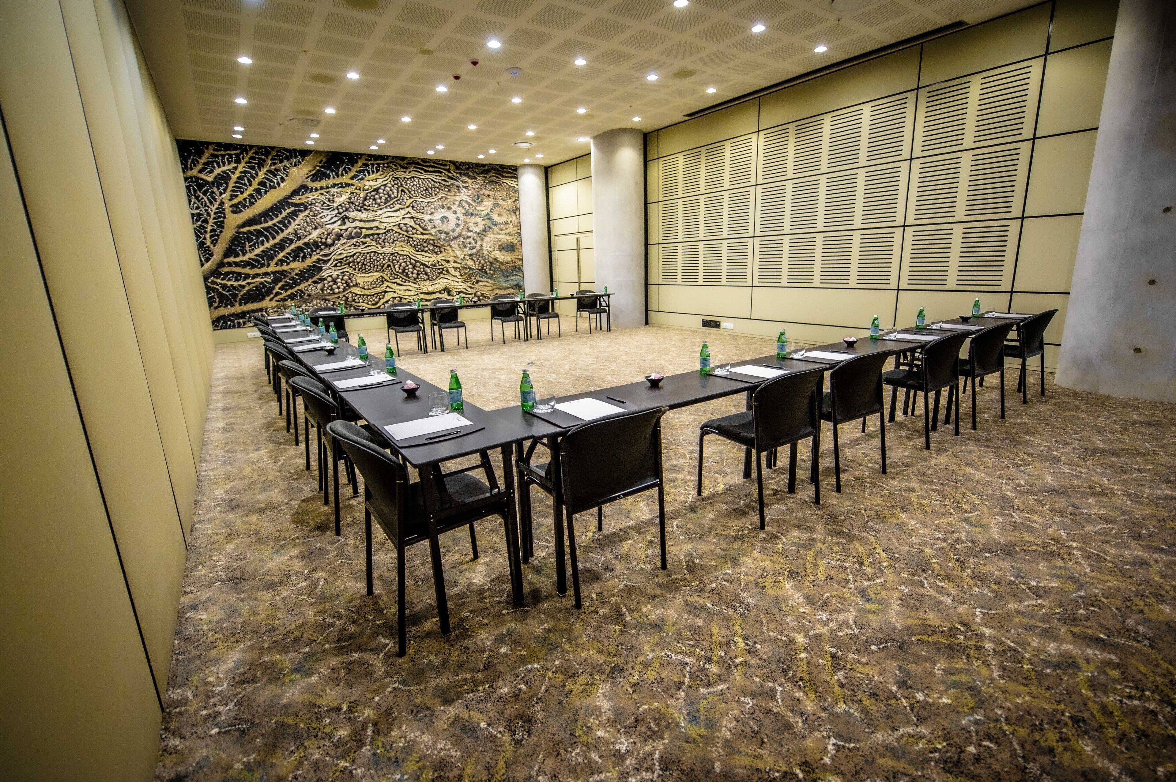 A conference room with a long table, chairs, and water bottles.