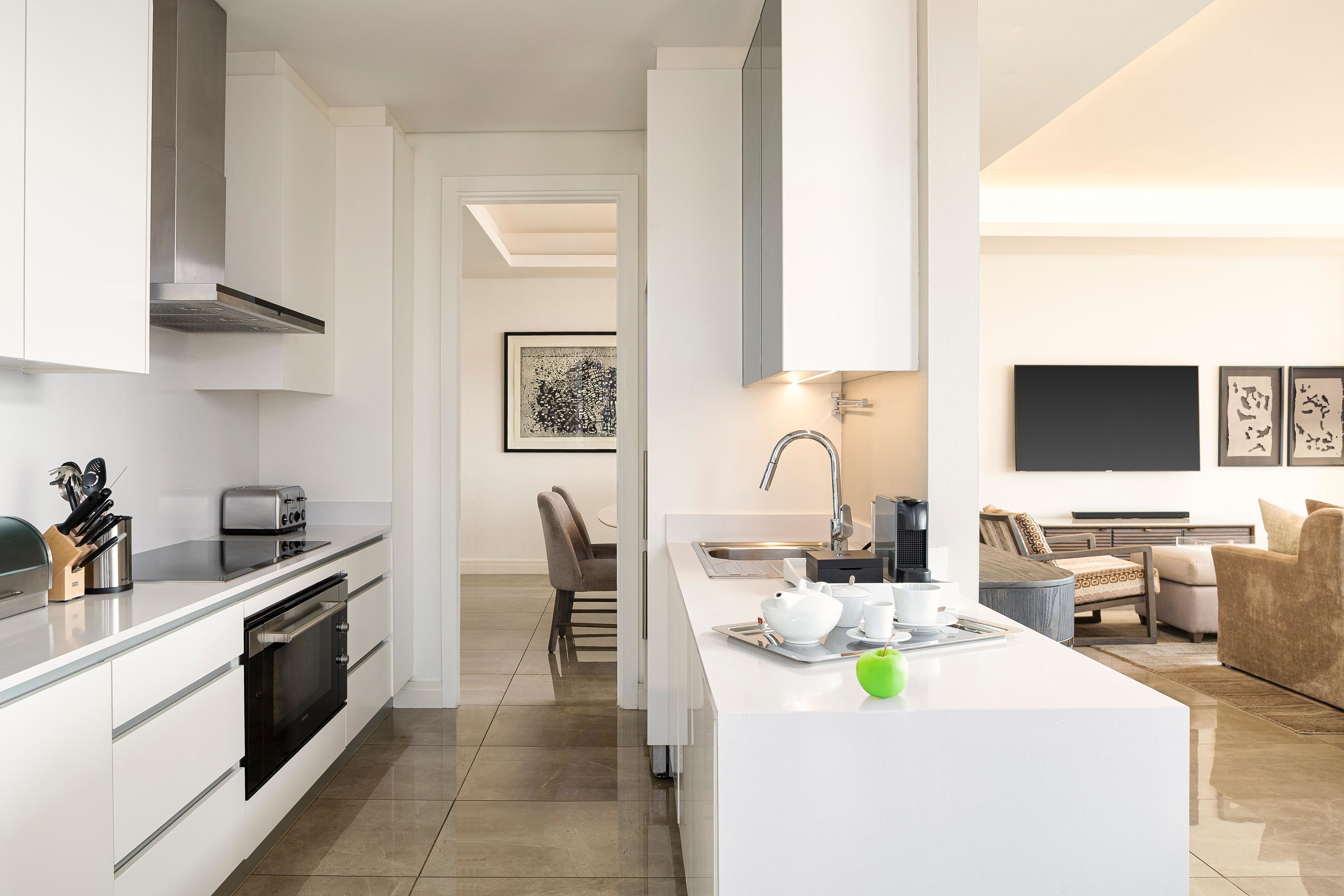 A modern kitchen with a central island, built-in oven, and stainless steel appliances.