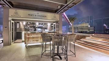 A bar area with a sign for 'MOËT & CHANDON Champagne' and a staircase leading to an upper level.
