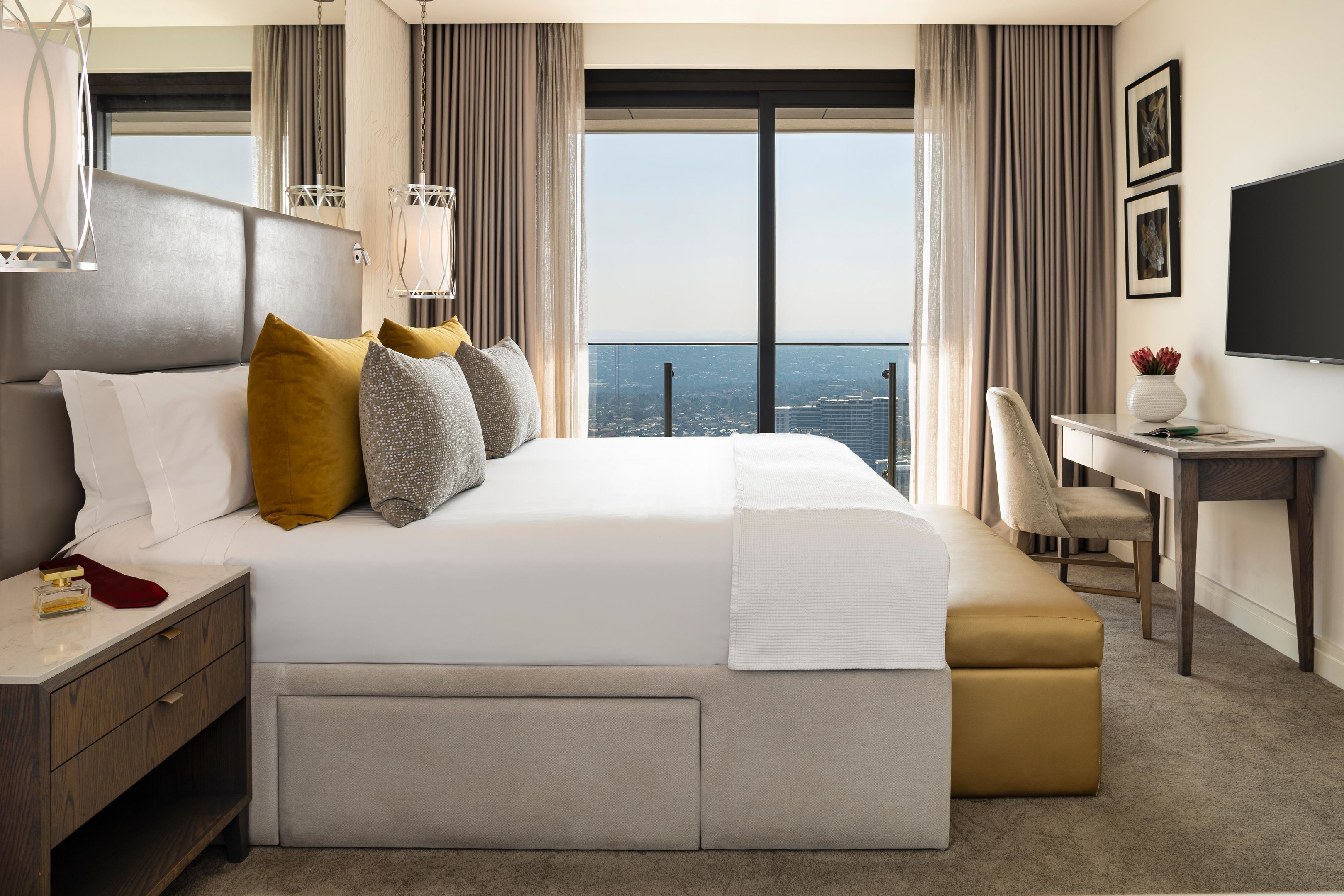 Une chambre d’hôtel moderne avec un grand lit, un bureau et une vue sur la ville.