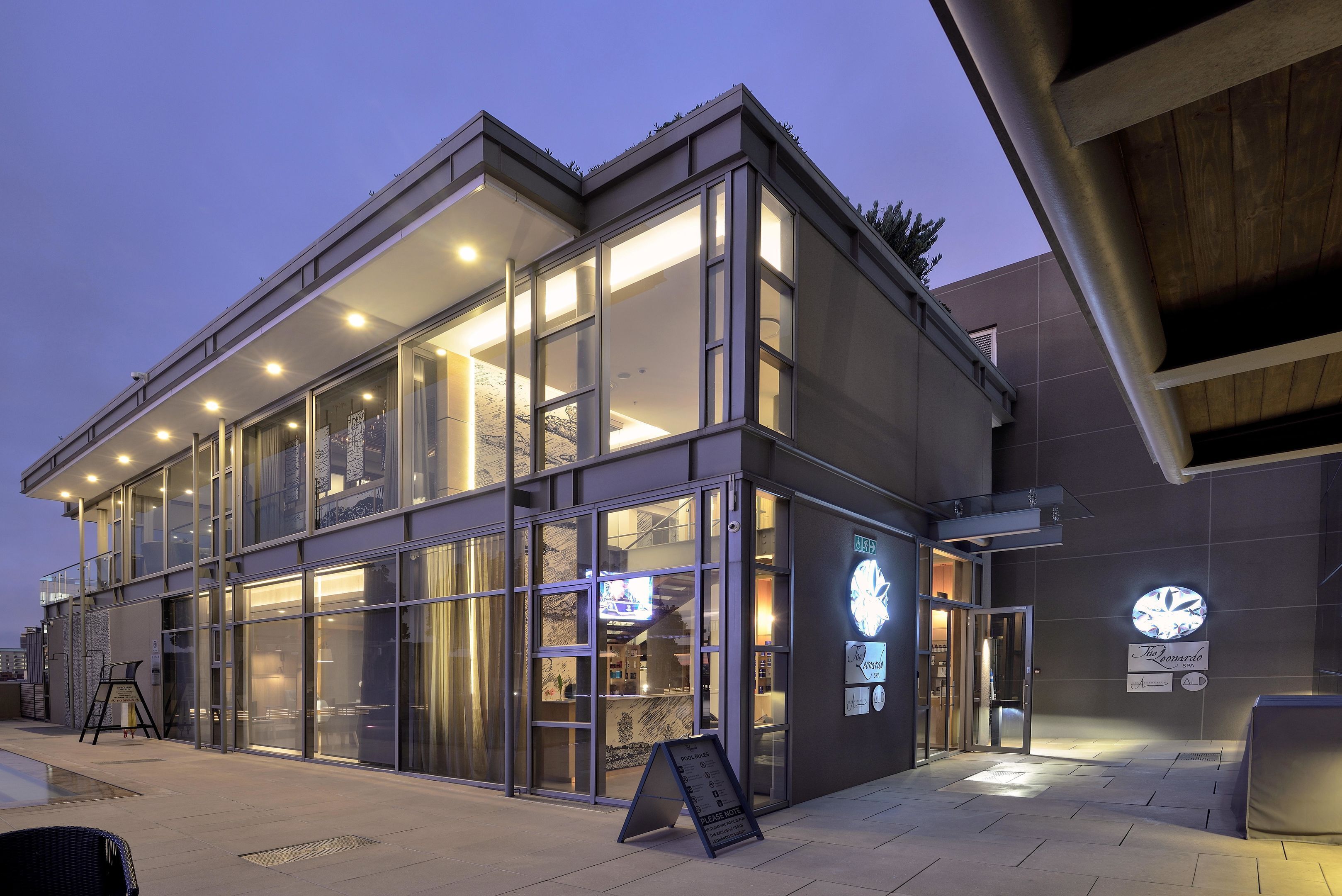 A modern building with large glass windows and a sign indicating a restaurant.