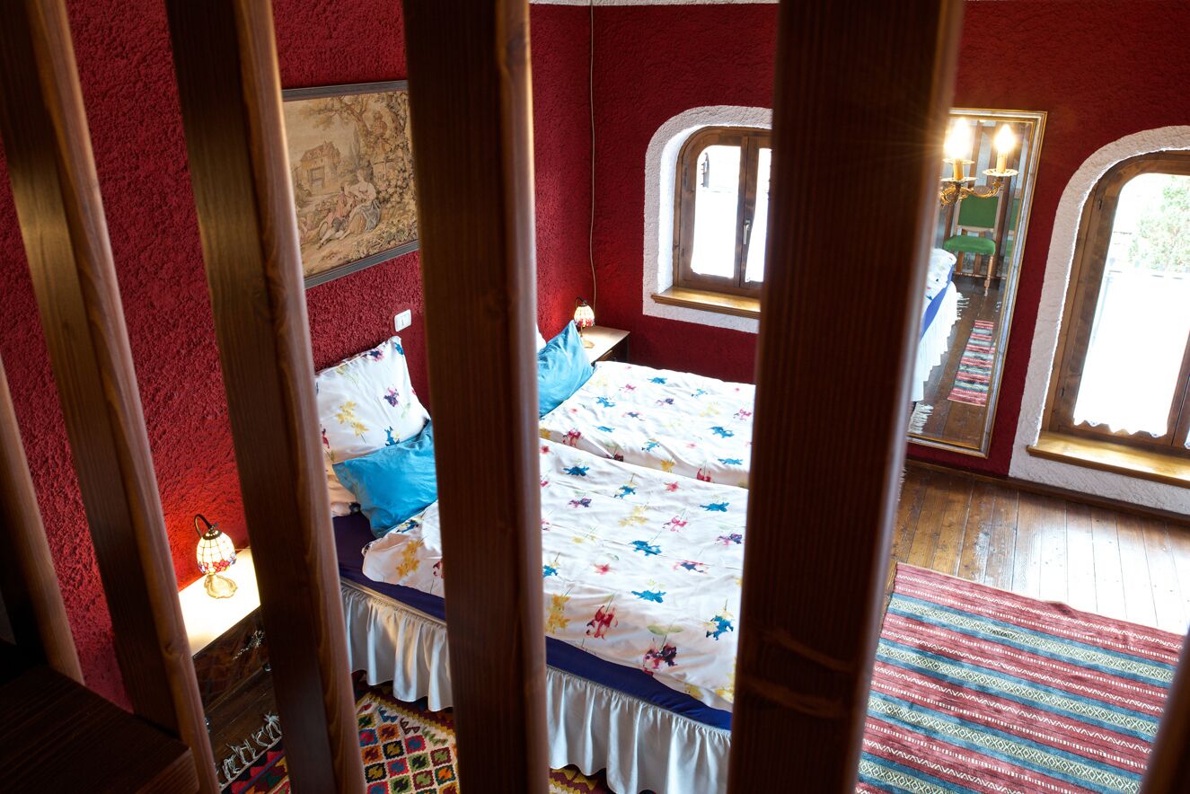 A bedroom with a bed, a window, and a mirror.