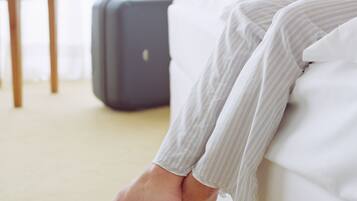 A bed with a suitcase in the background.