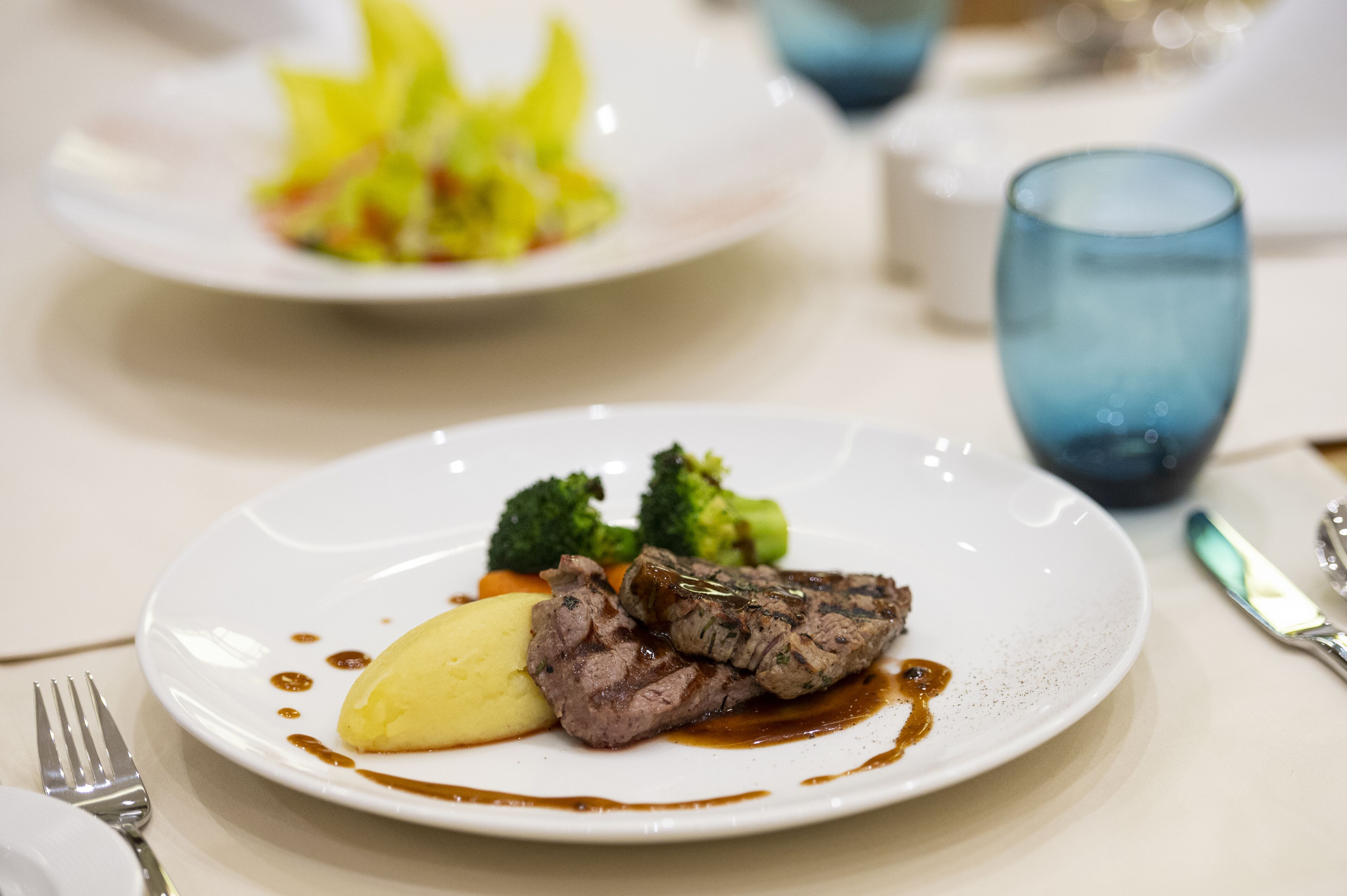 A plate of food with steak, broccoli, and mashed potatoes.